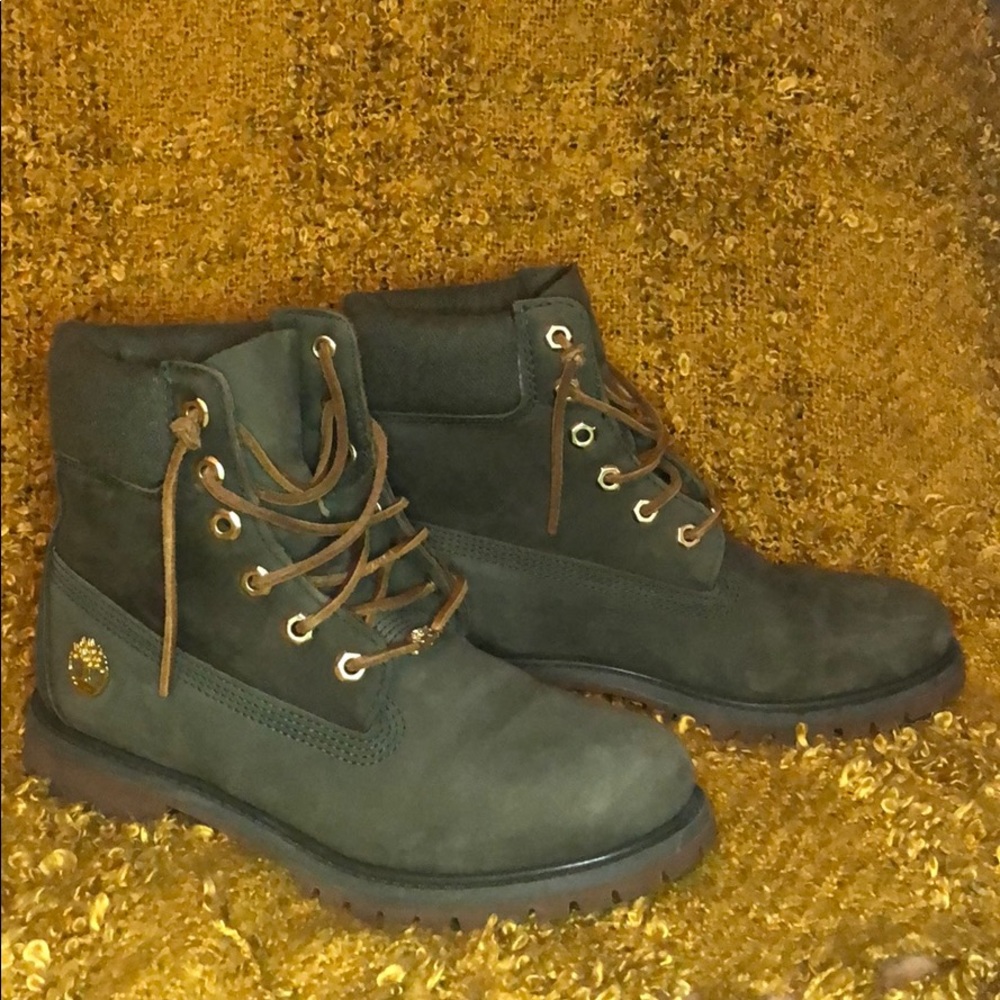 Timberland women’s boots green with gold accents.